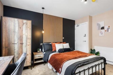A stylish double bedroom featuring a cozy bed w...
