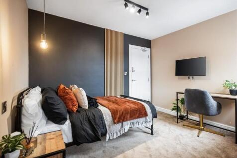 A stylish single bedroom featuring a cozy bed w...