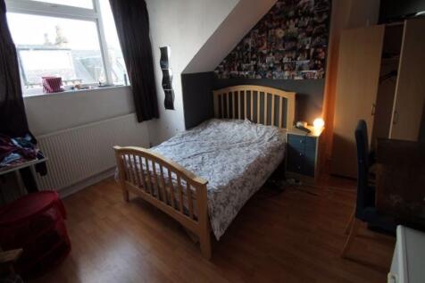 Cozy double bedroom featuring a wooden bed fram...