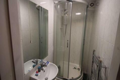 A clean, modern bathroom featuring a corner sho...