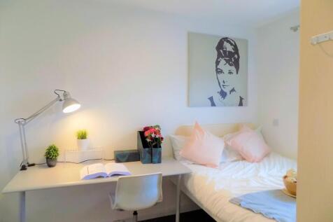 A cozy and neat single bedroom featuring a well...