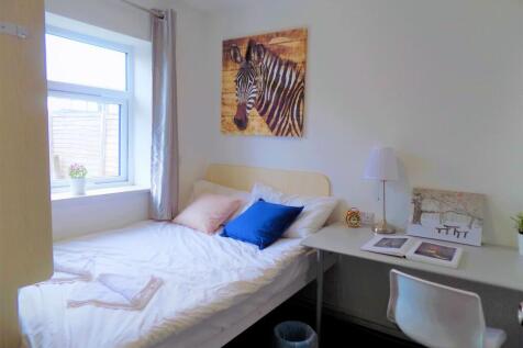 A cozy single bedroom featuring a comfortable b...