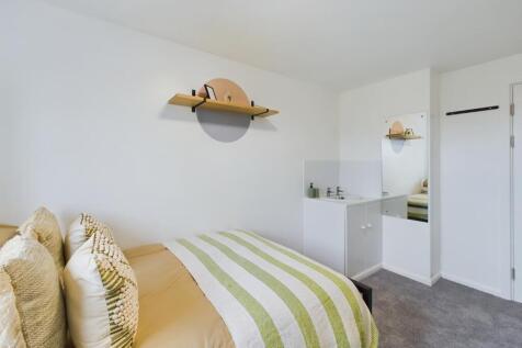 A bright and tidy double bedroom featuring mode...