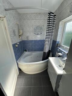 Bright and clean bathroom suite featuring a cor...