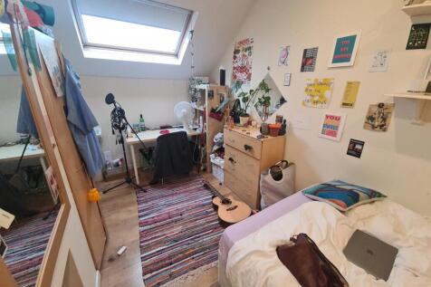 Cozy single bedroom featuring a comfortable bed...