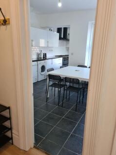 A modern kitchen featuring sleek white cabinets...