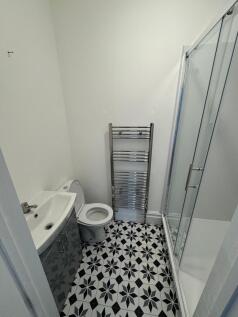 A modern bathroom featuring a patterned black a...