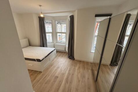 Spacious double bedroom featuring large windows...