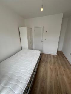 A bright and tidy single bedroom featuring a co...