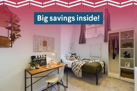 A well-lit, cozy bedroom featuring a comfortabl...