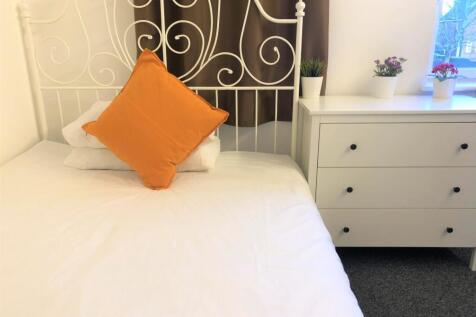 A cozy double bedroom featuring a stylish white...