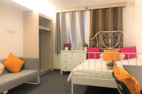 A cozy double bedroom featuring a white metal b...