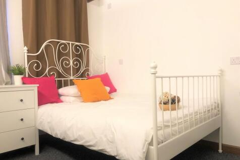 A cozy double bedroom featuring a stylish white...