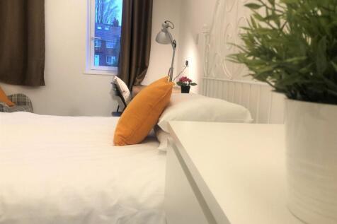 A cozy and neatly arranged double bedroom featu...