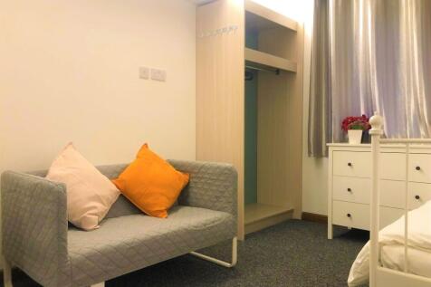 Cozy single bedroom featuring a comfortable sof...