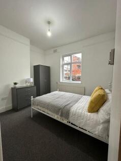 A neat and tidy double bedroom featuring a comf...
