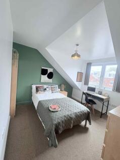 A stylish double bedroom with a comfy bed, a mo...