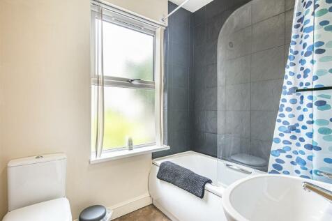 A stylish bathroom featuring a modern bathtub a...