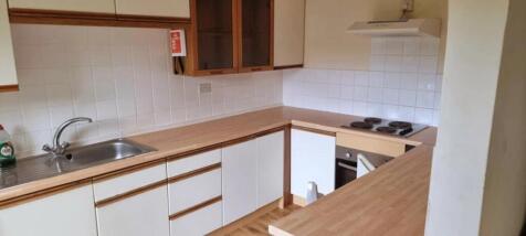 A neat kitchen featuring ample wooden counterto...
