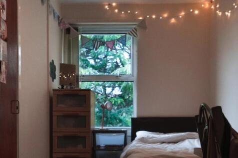 A cozy single bedroom featuring a neatly made b...