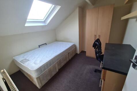 A cozy single bedroom featuring a comfortable b...