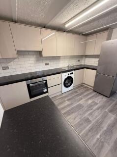 This modern kitchen features sleek, high-gloss ...