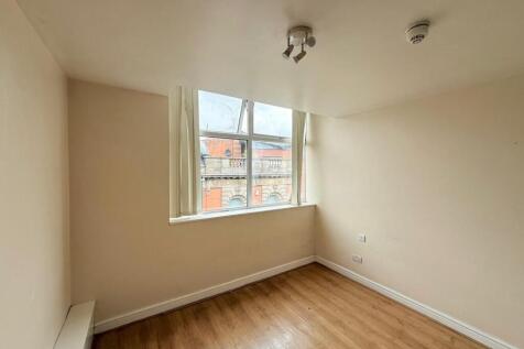 A bright and tidy empty single bedroom featurin...