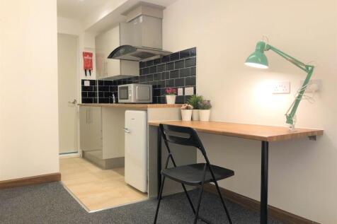 A compact, modern kitchen area featuring a slee...