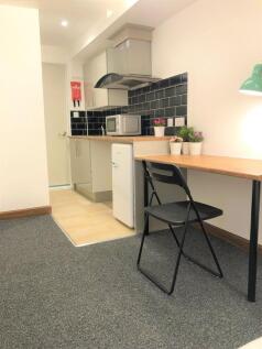 A modern and tidy kitchenette featuring a compa...
