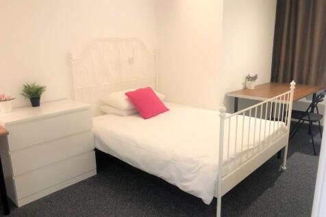 A neat and bright single bedroom featuring a wh...