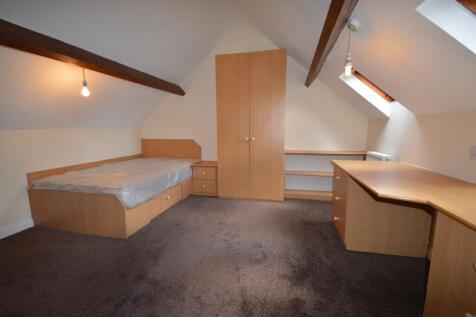 A cozy attic bedroom featuring built-in wooden ...