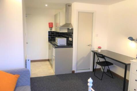 A bright and tidy single bedroom featuring a co...