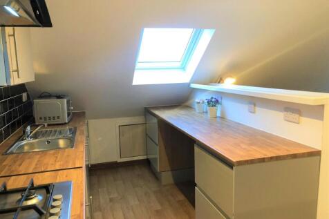 A bright and tidy kitchen featuring modern wood...