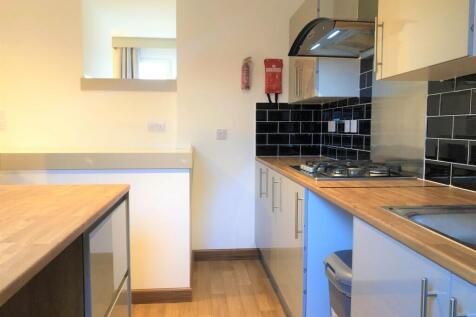 A modern kitchen with sleek black tiled splashb...
