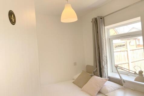 A cozy and tidy single bedroom featuring a comf...