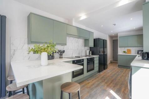 Modern kitchen with stylish green cabinetry, wh...