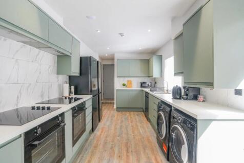 Modern kitchen featuring sage green cabinets, a...