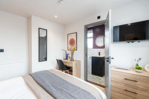 A bright and modern bedroom featuring a comfort...