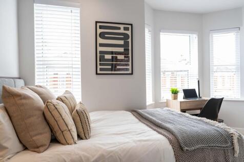 A bright and inviting bedroom featuring multipl...