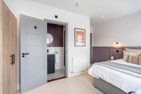 Bright, stylish master bedroom with a cozy atmo...