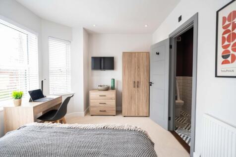 Bright and airy master bedroom featuring two la...