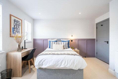 Bright and modern bedroom featuring a comfortab...