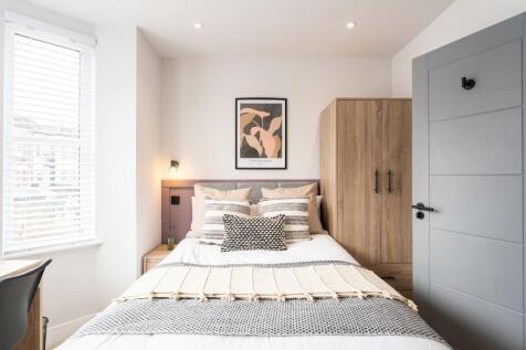 A bright and modern double bedroom featuring a ...