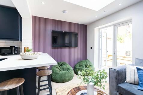 Bright and modern living room featuring a large...