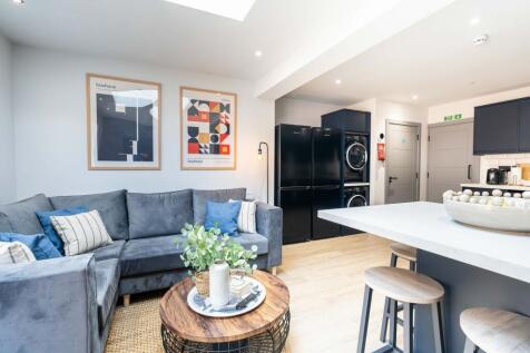 Bright and modern living room featuring a comfo...