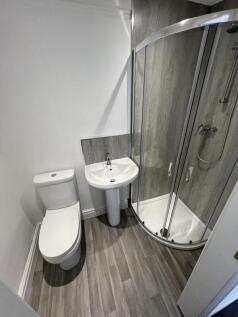 A modern bathroom featuring a sleek curved glas...