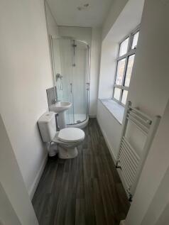 Bright and tidy bathroom featuring a corner sho...