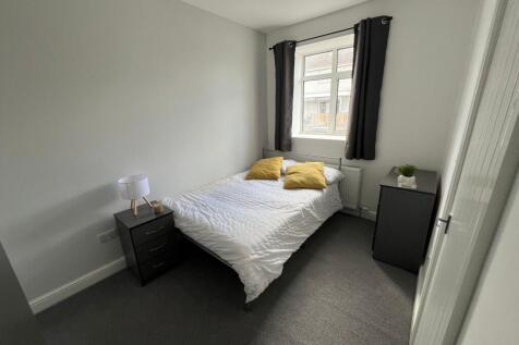 A cozy double bedroom featuring a neatly made b...