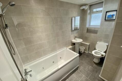 A spacious and modern bathroom featuring a rela...
