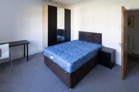 A clean and bright bedroom featuring a comforta...